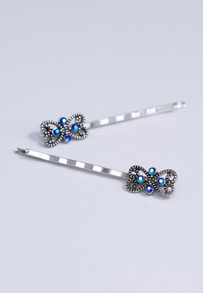 Simple ornate bobby pin with sparkling blue accents.