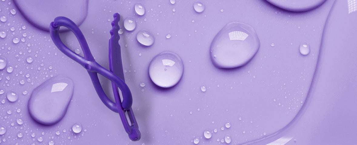 Purple waterproof Flexi Sport hair clip on purple background with water droplets 