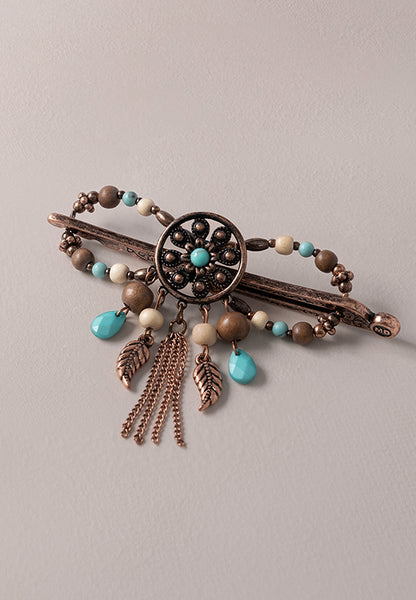 Nicoma Flexi Clip features a groovy flower round set in burnished coppertone with turquoise, cream and wood accents.