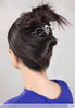woman with hair styled up in a dragon flexi clip with blue stones that match her blue top