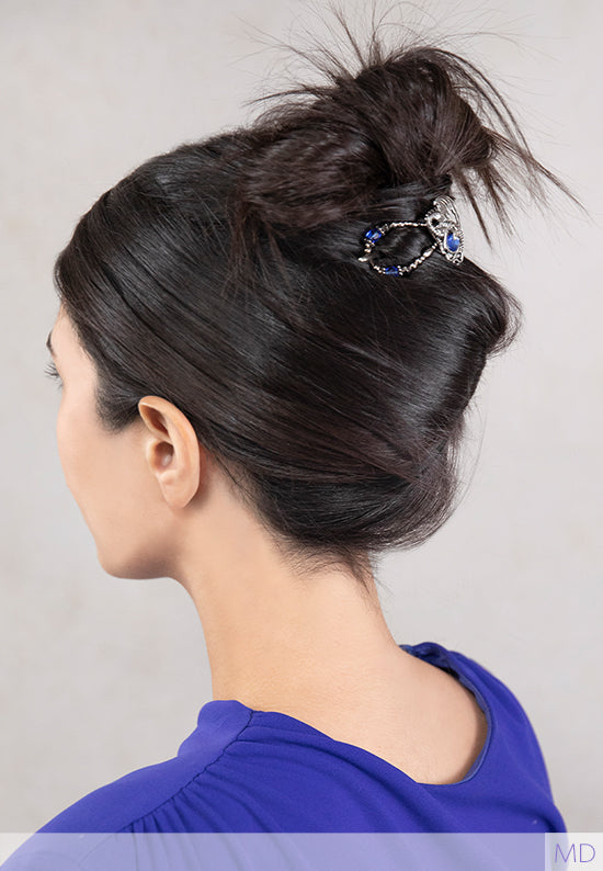 woman with hair held up in a dragon flexi clip with blue stones that match her blue top
