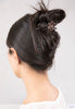 profile of a dark haired model wearing a black and copper flexi clip holding an all up hairstyle