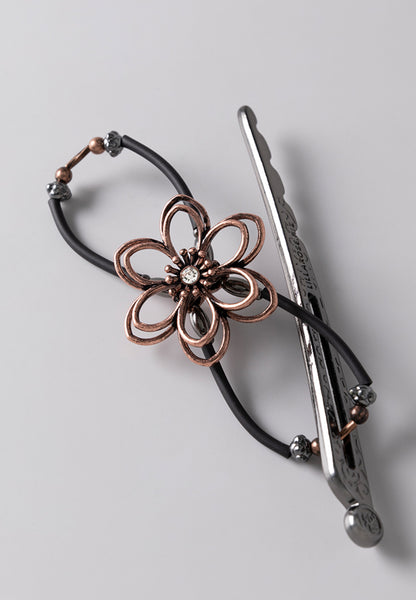 close up of a black flexi clip with a copper flower center
