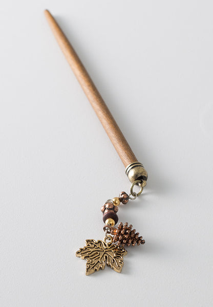 Hair stick with an autumn maple leaf dangle and pinecone with mixed metals accents.