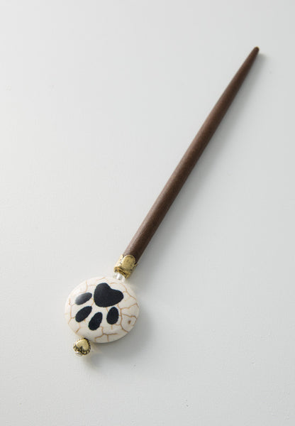 A round puff bead with a paw print hair stick.