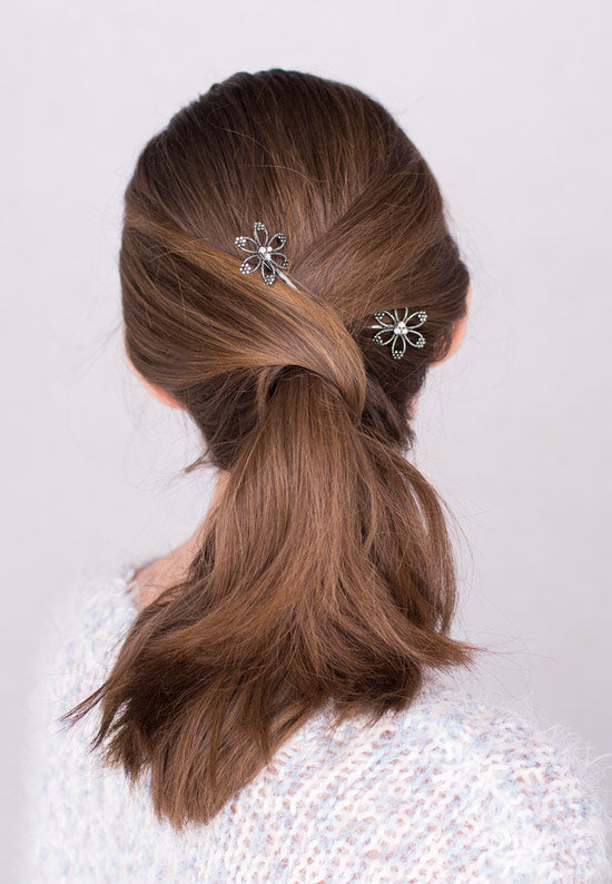 Open flower motif with three aurora borealis stones in this Bobby Pin in silvertone.