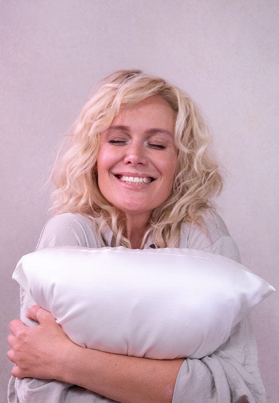 Woman hugging Silk sham encased pillow