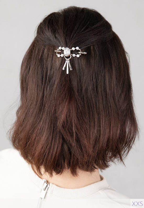 Tabitha Flexi Clip features an oval stoneset with paddle drops and natural howlite stone accents. Shown in hair in white.