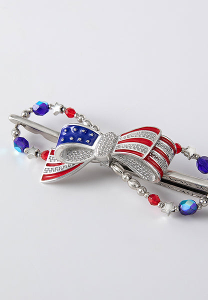 Betsy Flexi Clip features a patriotic bow bursting with bright blue and ruby red colors complemented by star bead accents.