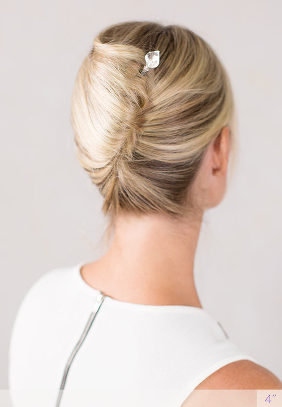 Silver Calla Lily tops a fark wooden stick.