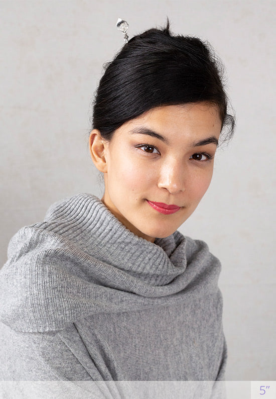 Silver Calla Lily tops a fark wooden stick.