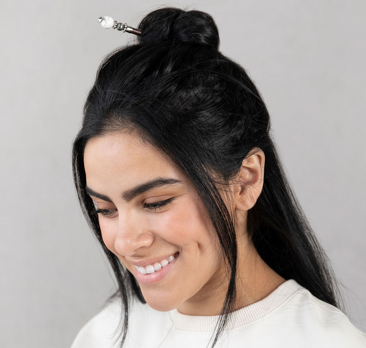 Tabitha hair stick in white shown in hair.