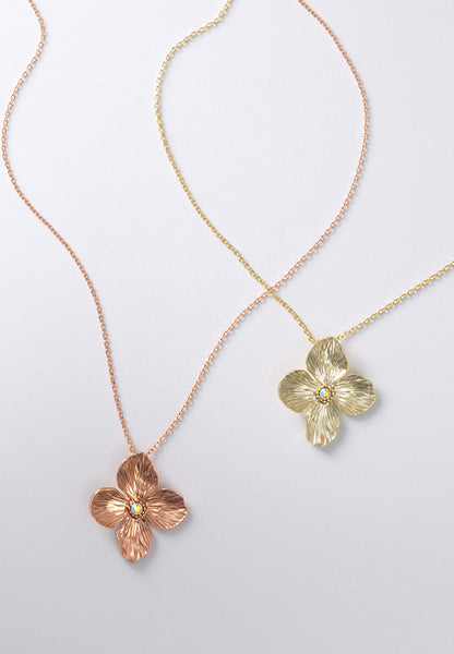 Posie necklaces in brasstone and rose goldtone feature a pure and precious flower with crystal aurora borealis center stone.